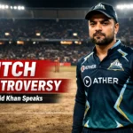 Rashid Khan अहमदाबाद क्रिकेट स्टेडियम की पिच पर खड़े हुए, पिच विवाद के बीच गंभीर भाव के साथ, बैकग्राउंड में रोशनी से जगमगाता स्टेडियम और “Pitch Controversy” ब्रेकिंग न्यूज़ टेक्स्ट दिखाई देता हुआ।